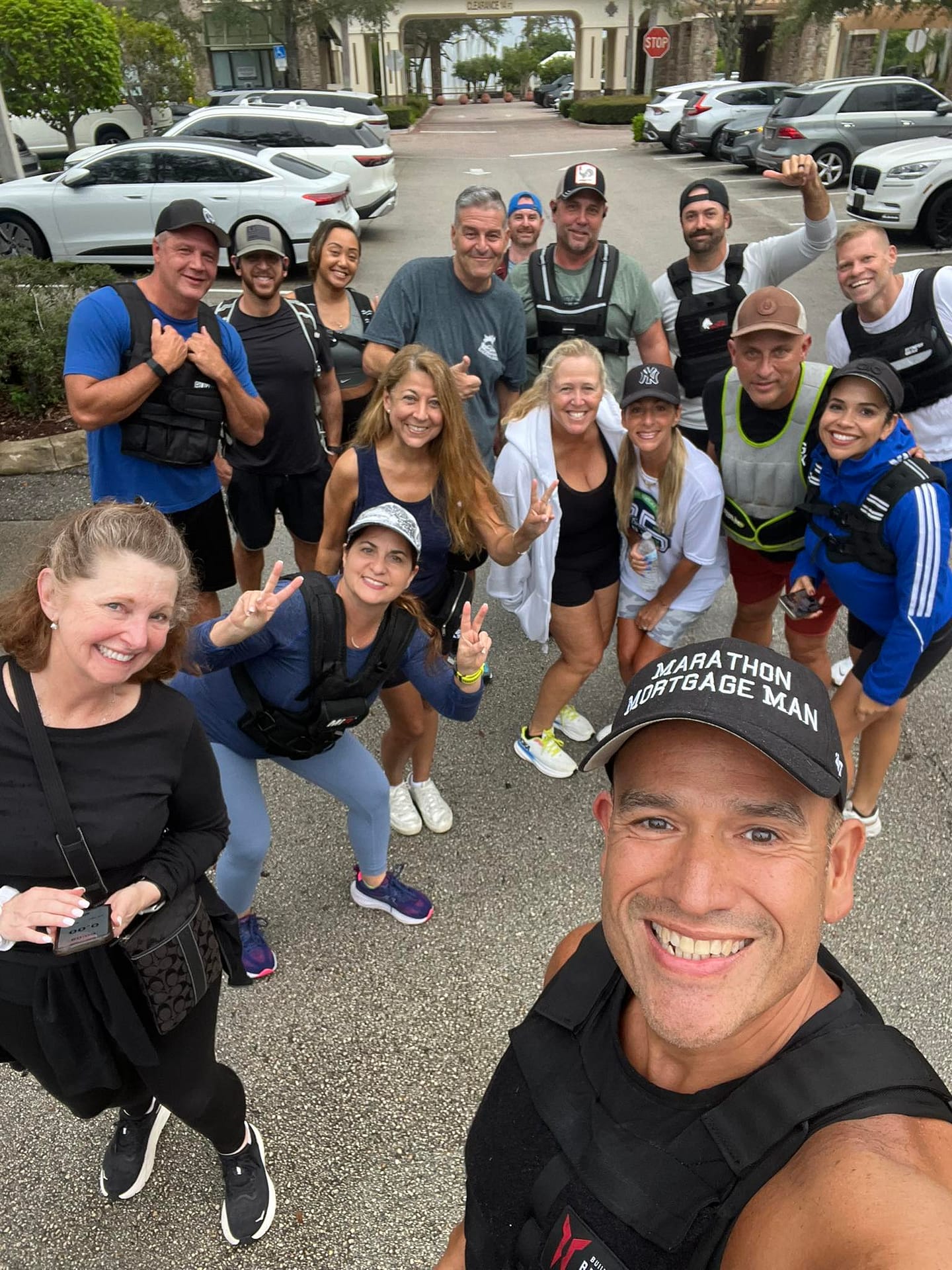 Group of people wearing weighted vests and smiling during a ruck in Parkland, Florida